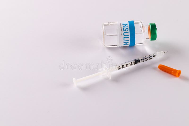 Insulin vial and uncapped syringe on white background with copy space. Blood sugar, diabetes and health awareness. Insulin vial and uncapped syringe on white background with copy space. Blood sugar, diabetes and health awareness.