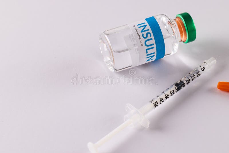 Insulin vial and uncapped syringe on white background with copy space. Blood sugar, diabetes and health awareness. Insulin vial and uncapped syringe on white background with copy space. Blood sugar, diabetes and health awareness.