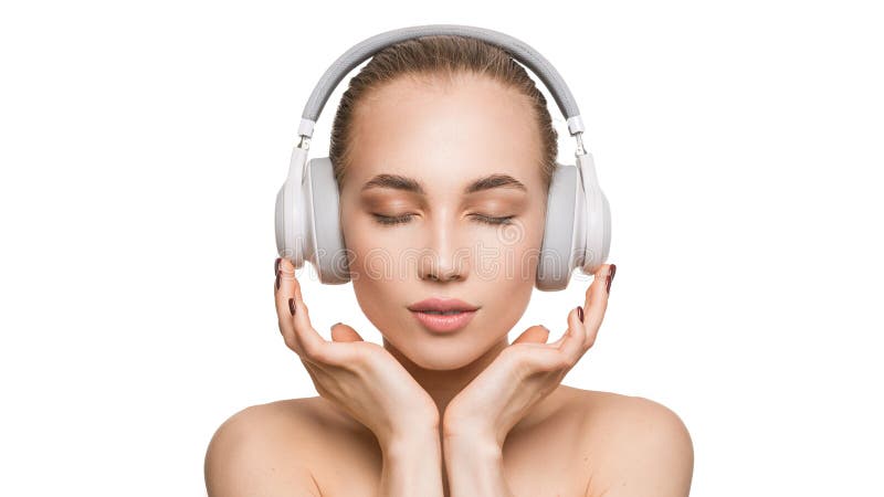 Woman in white headphones on white background listens to music with closed eyes. Woman in white headphones on white background listens to music with closed eyes