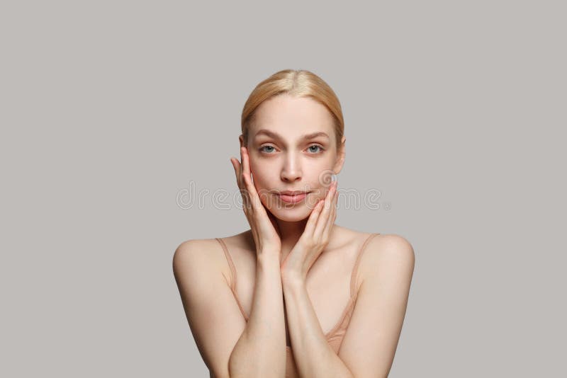 白色背景上用双手触摸脸部的漂亮可爱女士的特写 库存图片