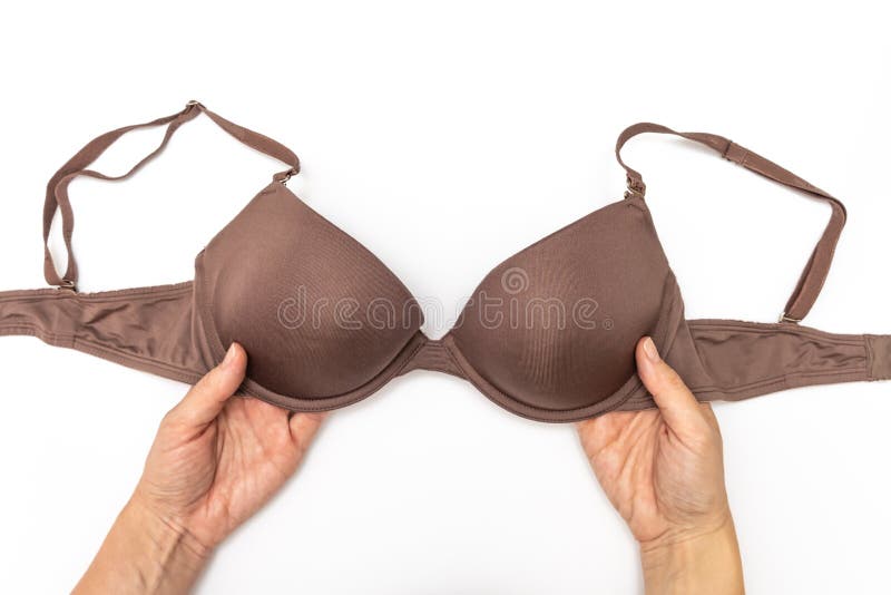 Female woman hands holding brown spotted bra on white background. Female woman hands holding brown spotted bra on white background.