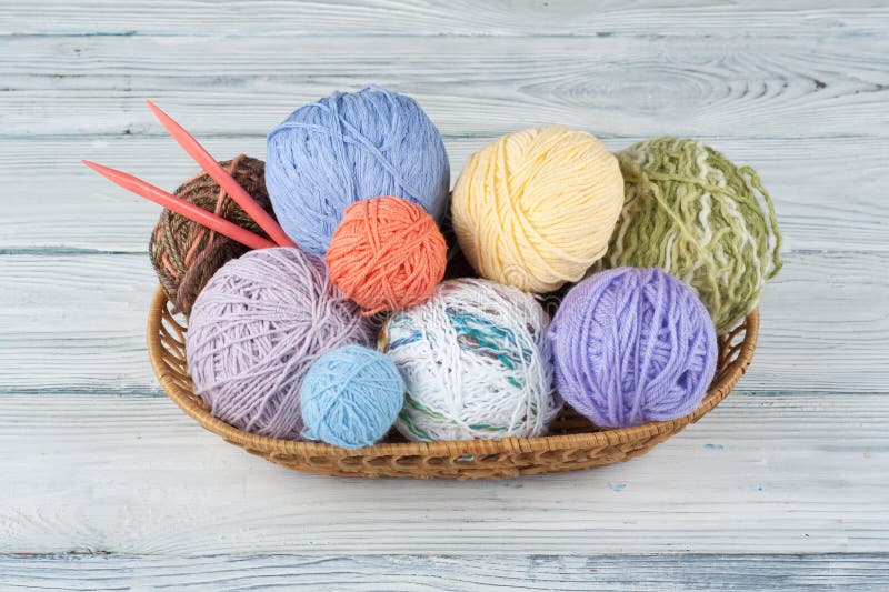 Colored yarn on a white background. Skeins of wool yarn for knitting. Balls of wool of different colours for handmade knitting on a wooden background with copy space for ad. Colored yarn on a white background. Skeins of wool yarn for knitting. Balls of wool of different colours for handmade knitting on a wooden background with copy space for ad