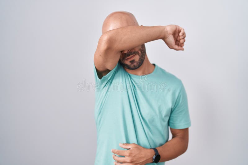 白色背景中站着的中年秃子，双臂看上去严肃而悲伤 免版税库存照片