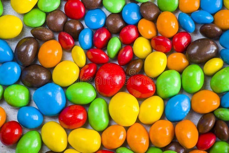 M&M`s candy on the white background, colorful candy texture, multicolored gradient. M&M`s candy on the white background, colorful candy texture, multicolored gradient.