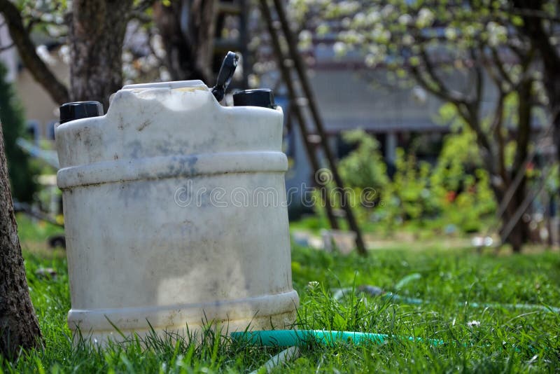 Water tank for watering the grass. Container to retain rainwater in the garden. White plastic jerrycan. Gallon water reserve . Water tank for watering the grass. Container to retain rainwater in the garden. White plastic jerrycan. Gallon water reserve .