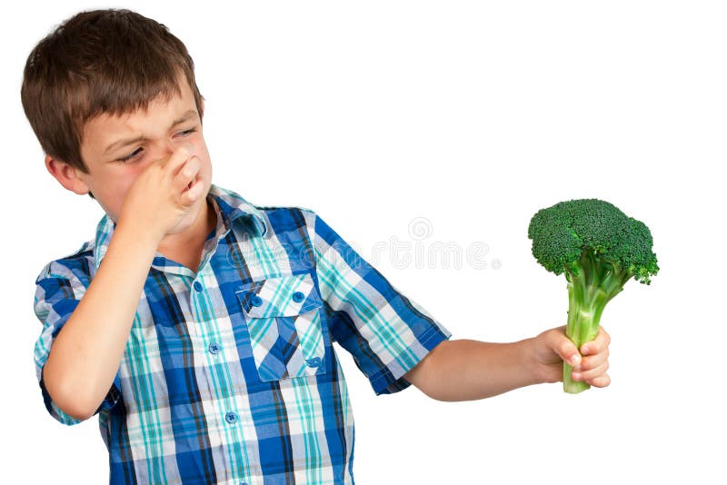 Small boy staring at a bunch of broccoli with disgust. Small boy staring at a bunch of broccoli with disgust