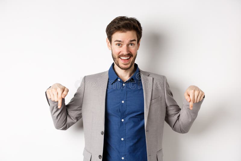 Hey check this out. Happy businessman in suit pointing fingers down and smiling, inviting to event, showing link, standing on white background. Hey check this out. Happy businessman in suit pointing fingers down and smiling, inviting to event, showing link, standing on white background.