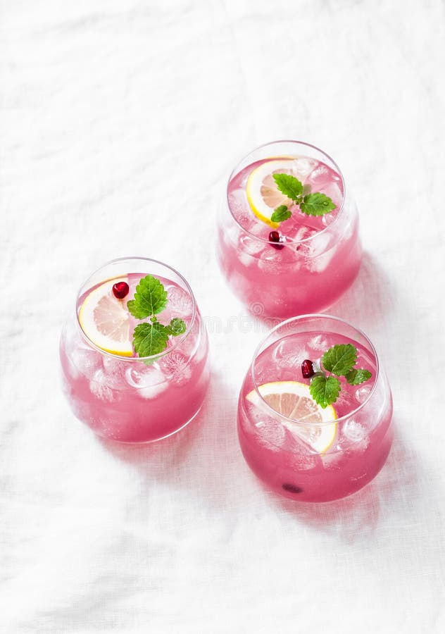 Pomegranate tequila cocktail. Summer light alcoholic drink, cooling aperitif. On light background, top view, free space. Flat lay. Pomegranate tequila cocktail. Summer light alcoholic drink, cooling aperitif. On light background, top view, free space. Flat lay