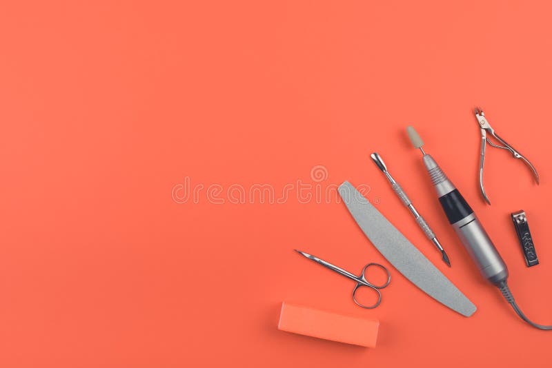 硬件杂种修指甲，钉子在珊瑚背景的关心集合 电钉子钻子笔，文件，缓冲，抛光的块，偏锋技巧 免版税库存图片