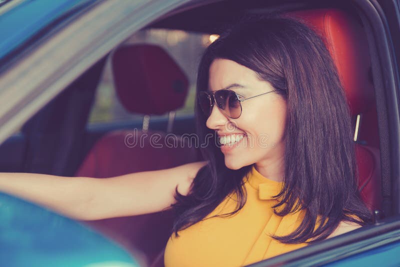 Confident and beautiful. Attractive young woman in yellow dress in her new modern car smiling. Confident and beautiful. Attractive young woman in yellow dress in her new modern car smiling