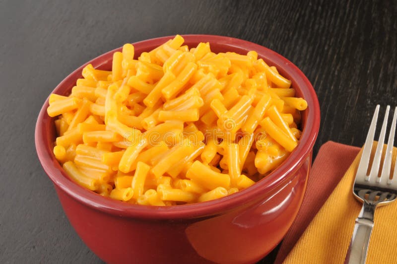 A bowl of macaroni and cheese on a simple setting. A bowl of macaroni and cheese on a simple setting