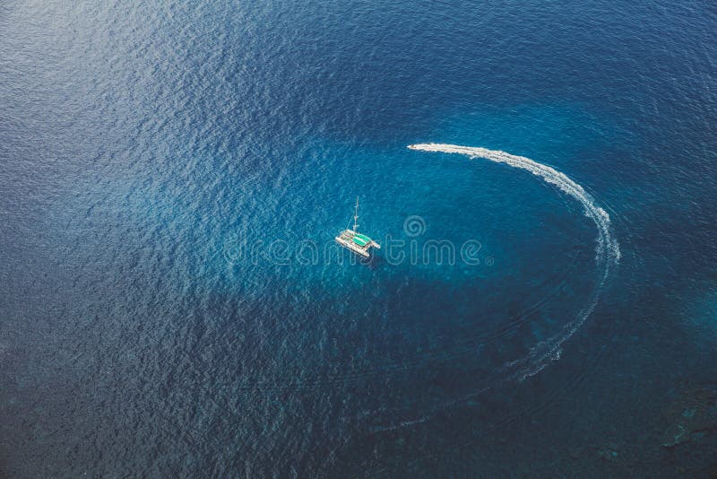 碧蓝海水中双体船的海景和摩托车绕船行驶 平静的美丽水域 免版税库存图片 碧蓝海水中双体船的海景和摩托车绕船行驶 平静的美丽水域 免版税库存图片