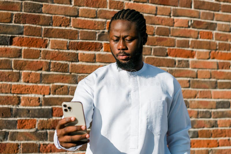 African American man checks cell phone in the street cafe in summer day. Millennial generation and gen z people. Social networks and dating app. African American man checks cell phone in the street cafe in summer day. Millennial generation and gen z people. Social networks and dating app