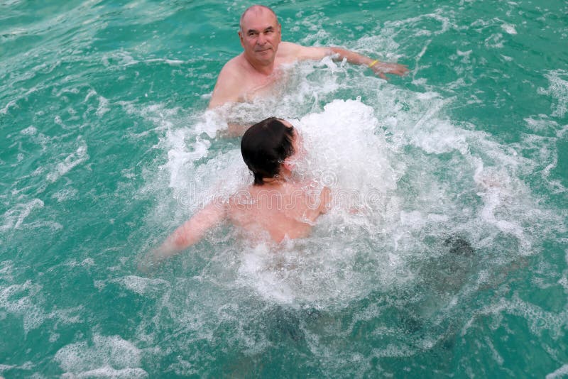 Grandfather with grandson get hydromassage in warm thermal pool, Adygea. Grandfather with grandson get hydromassage in warm thermal pool, Adygea