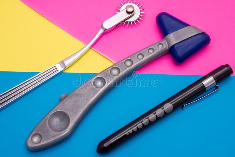 神经诊断工具：锤子、用于检查瞳孔对光的反应的手电筒、Wartenberg 轮或神经轮平放 免版税库存照片