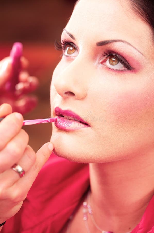 Close up of beautician creating makeup for a young women in the beauty parlour. Close up of beautician creating makeup for a young women in the beauty parlour.