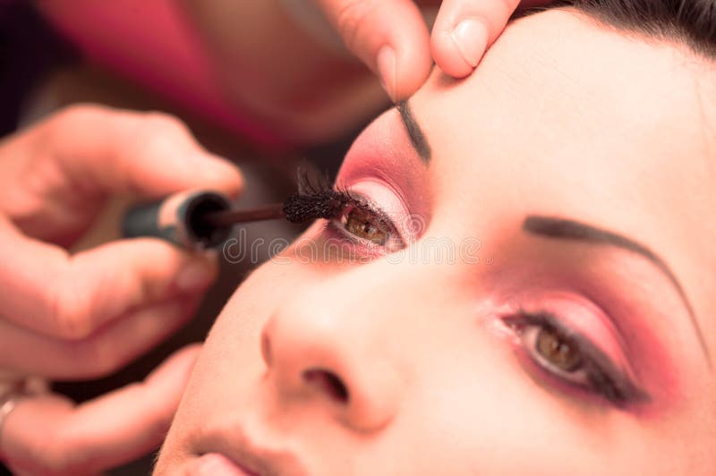 Close up of beautician creating makeup for a young women in the beauty parlour. Close up of beautician creating makeup for a young women in the beauty parlour.