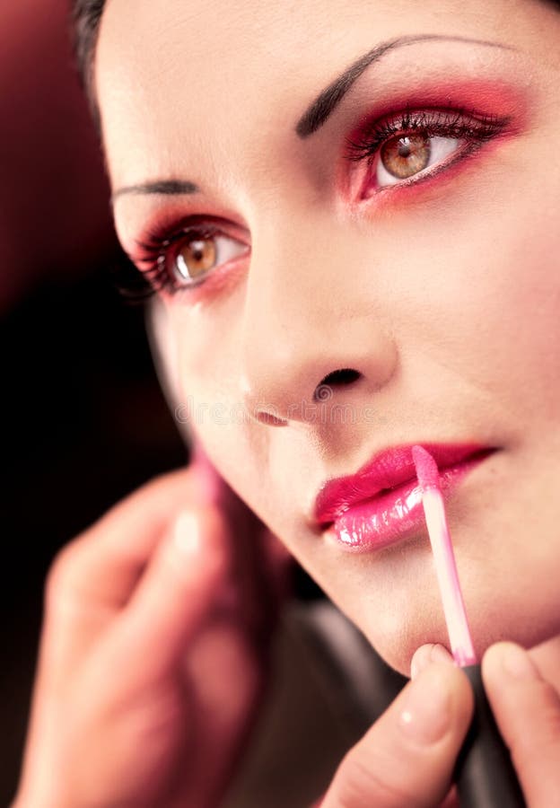 Close up of beautician creating makeup for a young women in the beauty parlour. Close up of beautician creating makeup for a young women in the beauty parlour.