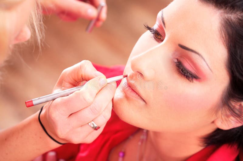 Close up of beautician creating makeup for a young women in the beauty parlour. Close up of beautician creating makeup for a young women in the beauty parlour.