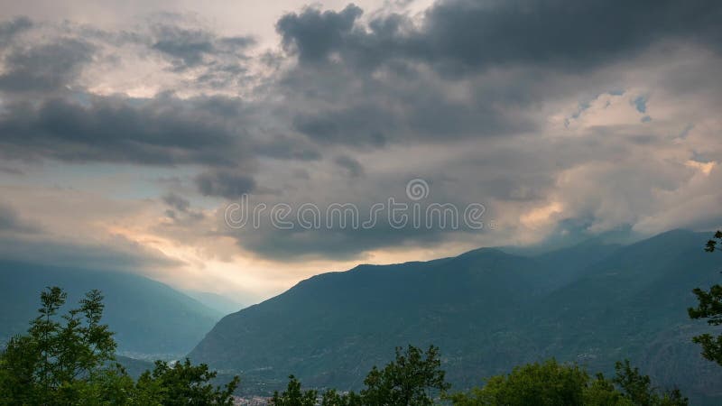 积雪覆盖的山土坎和峰顶与移动的云彩在阿尔卑斯在夏天，托里诺省，意大利 时间间隔