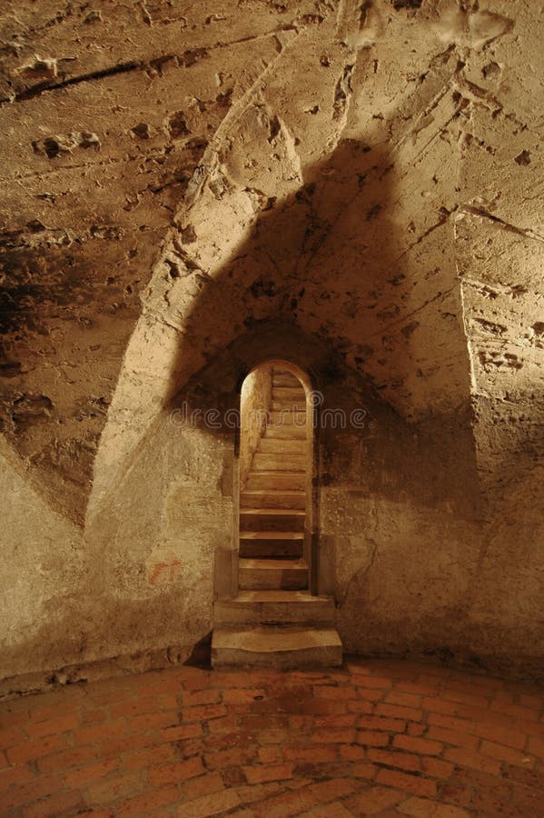 A dark crypt with massive arches cut in stone. A dark crypt with massive arches cut in stone.