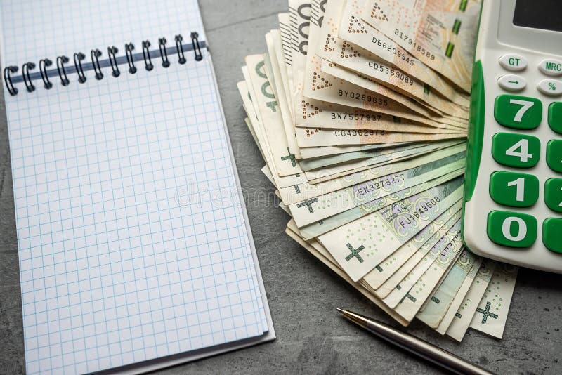 Empty notebook and pen with calculator 100 200 pln polish zloty money on desk. Concept of financial planning or buying list. Empty notebook and pen with calculator 100 200 pln polish zloty money on desk. Concept of financial planning or buying list