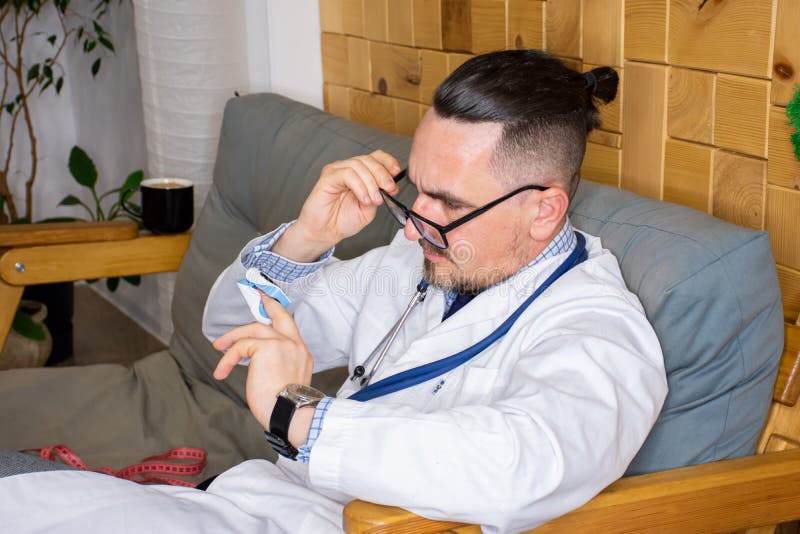 医生、护士或身穿白色无菌外套的医护人员将脉搏血氧仪戴在手指上，检查血液的氧饱和度 库存图片