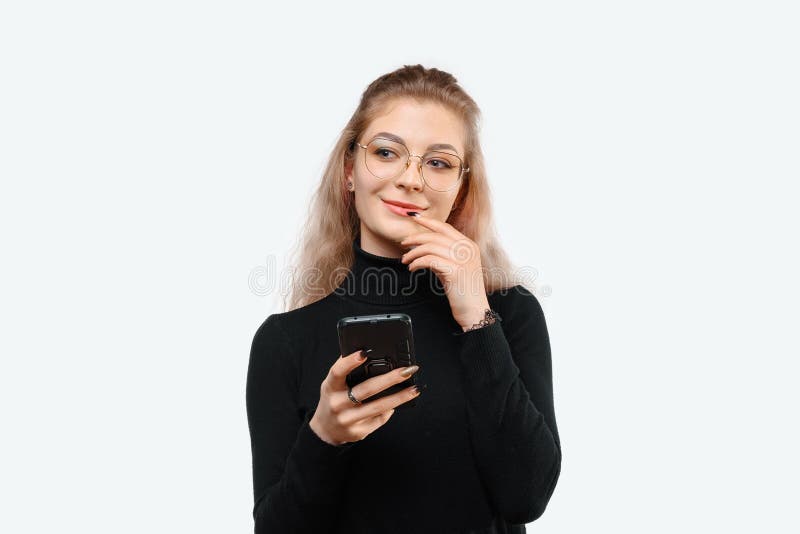 穿着便装的体贴年轻美女手持智能手机的照片. 白色背景 图库摄影