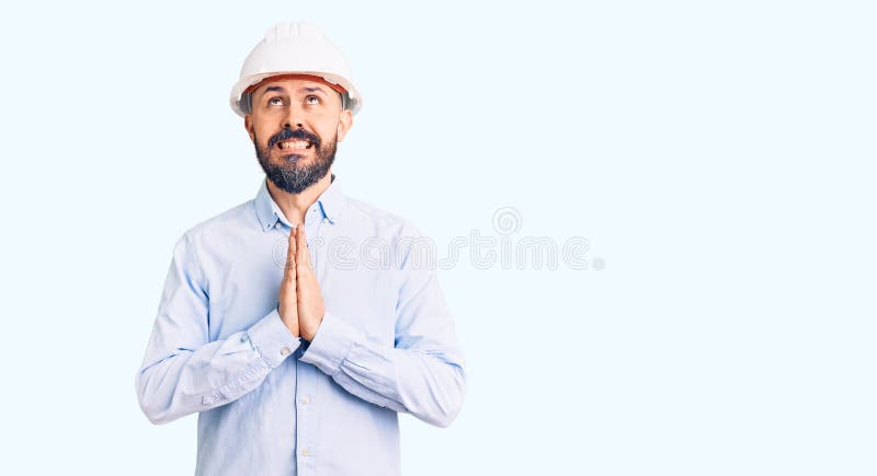 穿着建筑师精装的年轻帅哥乞讨和祈祷，带着希望的表情在脸上非常激动 免版税图库摄影
