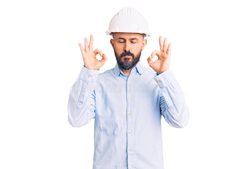 穿着建筑设计精装的年轻帅哥放松，用手指闭着眼睛做冥想手势 库存照片