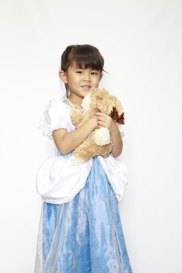 穿裙子的日本女孩手里拿着毛绒兔 免版税库存照片
