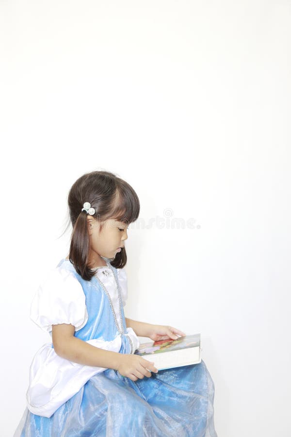 日本女孩穿着连衣裙读书 免版税库存图片