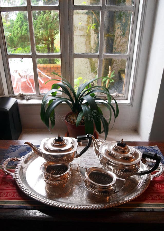 窗口设置的古色古香的银色茶具 库存照片