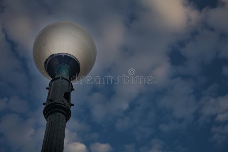 站立在多云昏暗的天空下的室外灯岗位角度图 一个街道灯笼特写镜头射击有抽烟的圆的 免版税图库摄影 站立在多云昏暗的天空下的室外灯岗位角度图 一个街道灯笼特写镜头射击有抽烟的圆的 免版税图库摄影