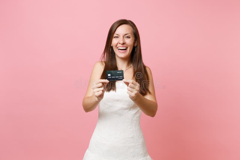 笑的新娘妇女画象显示在照相机的白色婚纱的信用卡在桃红色淡色背景 免版税图库摄影 笑的新娘妇女画象显示在照相机的白色婚纱的信用卡在桃红色淡色背景 免版税图库摄影