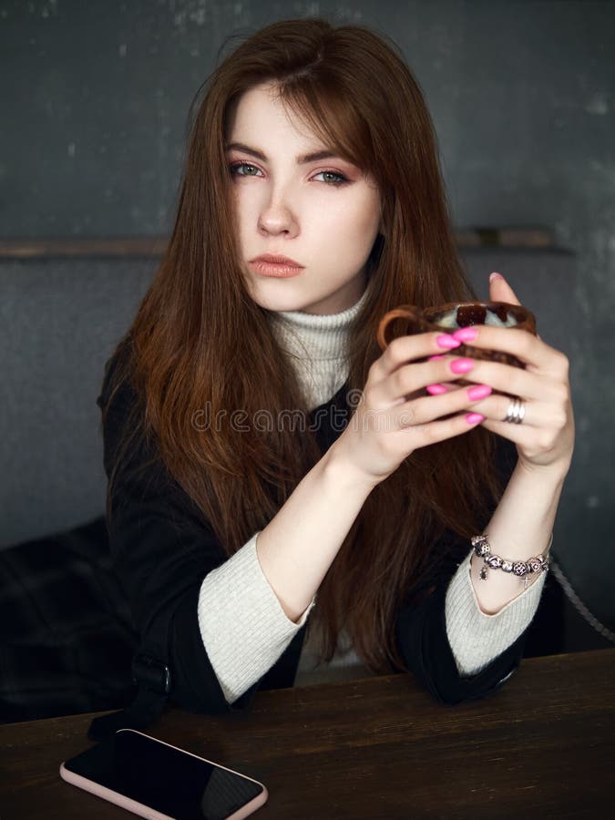 等待在咖啡馆的一名逗人喜爱的俏丽的红头发人妇女的画象享受时间与一个智能手机的咖啡休息在桌藏品工艺 库存照片 等待在咖啡馆的一名逗人喜爱的俏丽的红头发人妇女的画象享受时间与一个智能手机的咖啡休息在桌藏品工艺 库存照片