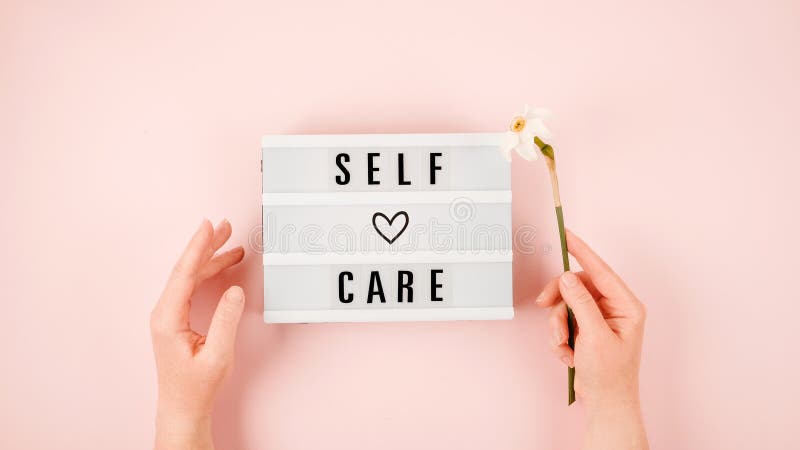 Self-care word on lightbox and flower narcissus on pink background flat lay. Take care of yourself. Self-care word on lightbox and flower narcissus on pink background flat lay. Take care of yourself