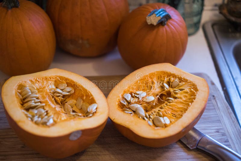 Small sugar pumpkin cut in half showing the seeds and pulp. Small sugar pumpkin cut in half showing the seeds and pulp.