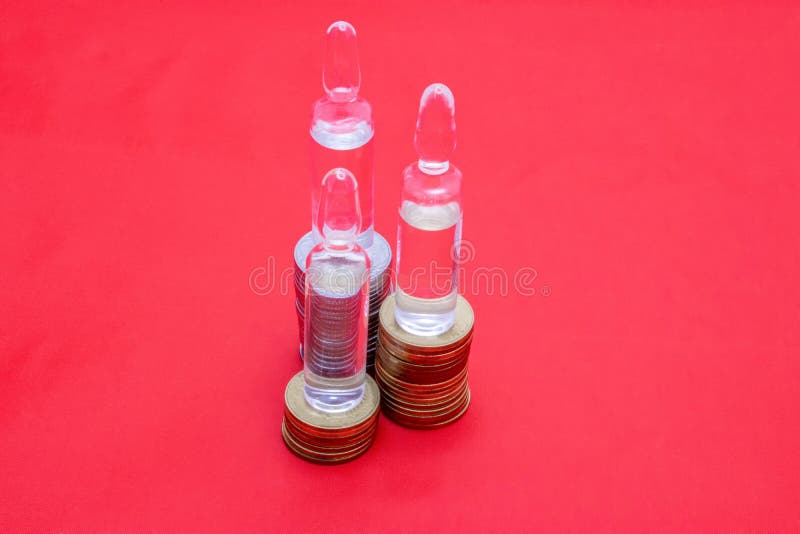 红色背景上的硬币上有透明的小瓶. 药品成本的说明. 用于打印机 免版税库存照片