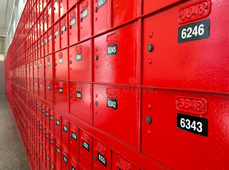 Red PO boxes in a post office with number range and postcodes written above them. Red PO boxes in a post office with number range and postcodes written above them.