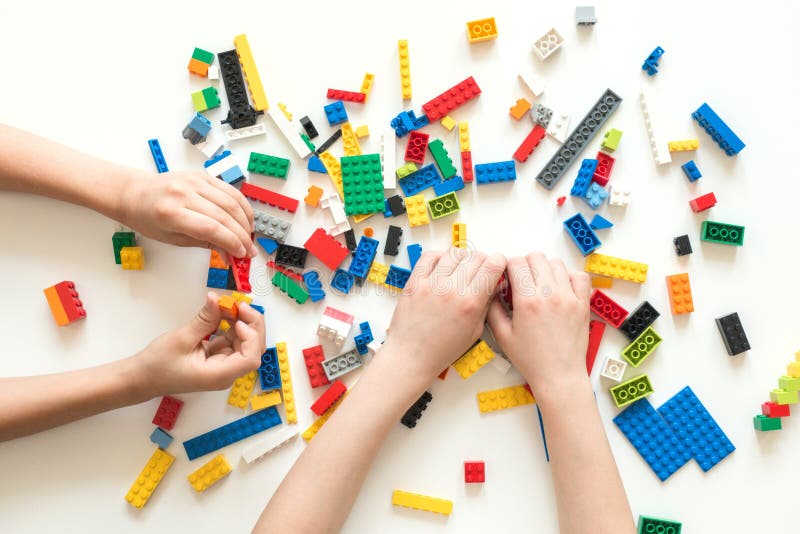 维尔纽斯，立陶宛- 2017年4月 孩子递与五颜六色的lego块的戏剧在白色桌上 库存照片