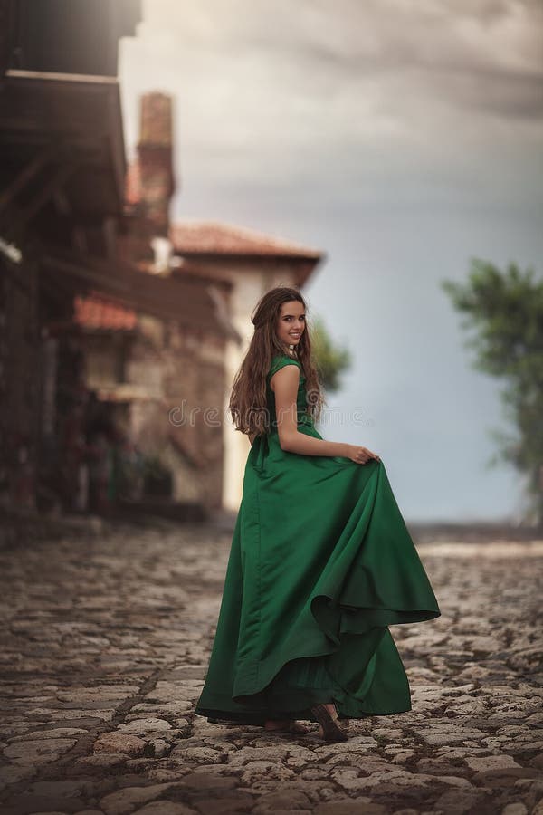 绿色礼服的妇女在老镇的街道上 假期旅行微笑的愉快走的年轻游人快乐 库存图片 绿色礼服的妇女在老镇的街道上 假期旅行微笑的愉快走的年轻游人快乐 库存图片
