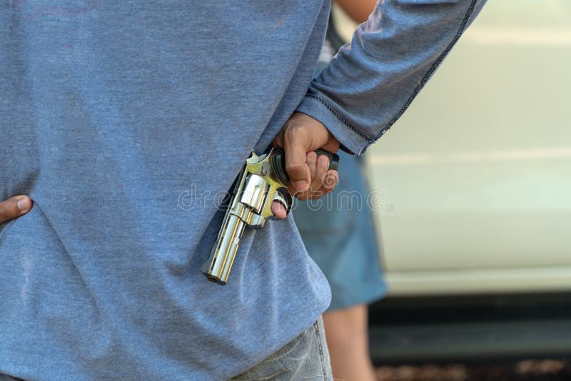 罪犯拿着在将打开车门的妇女后的一杆枪 社会问题和罪行灾害的概念 免版税库存图片 罪犯拿着在将打开车门的妇女后的一杆枪 社会问题和罪行灾害的概念 免版税库存图片