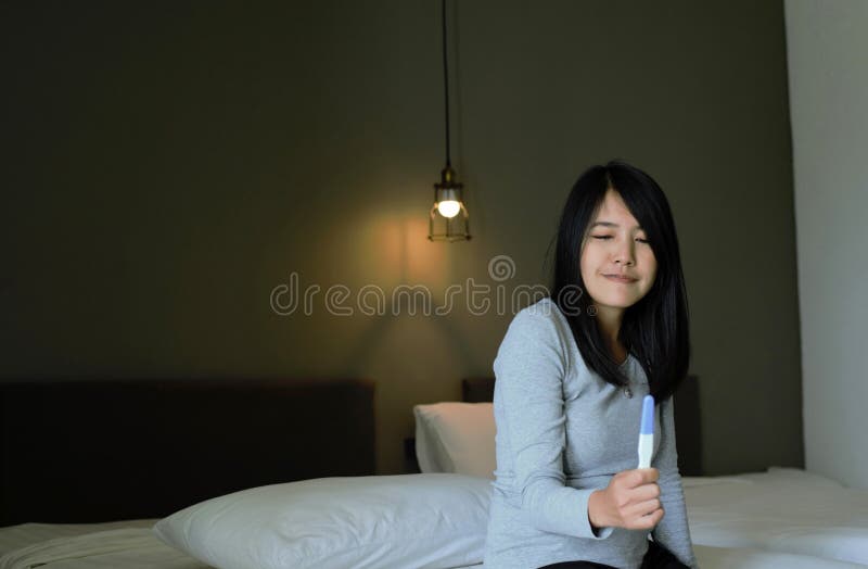 美丽亚洲妇女手陈列妊娠试验在测试在她的卧室,愉快和微笑以后 库存照片 美丽亚洲妇女手陈列妊娠试验在测试在她的卧室,愉快和微笑以后 库存照片