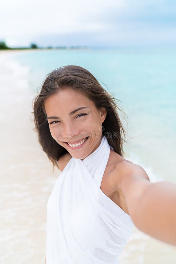 美丽的亚裔混合的族种妇女Selfie海滩佩带的白色包庇的