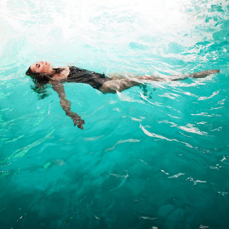 Beautiful girl is relaxing in the Spa pool,swim and relax. young woman floating in water on the back, copy space. Beautiful girl is relaxing in the Spa pool,swim and relax. young woman floating in water on the back, copy space