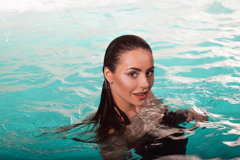 Beautiful girl is relaxing in the Spa pool, relaxing and taking care of herself. Profile portrait of a young woman floating in water. Beautiful girl is relaxing in the Spa pool, relaxing and taking care of herself. Profile portrait of a young woman floating in water