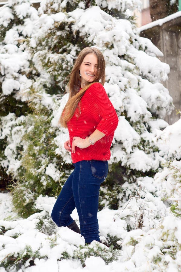 美好的女孩模型在冬天在一个停放的公园 在一件红色毛线衣