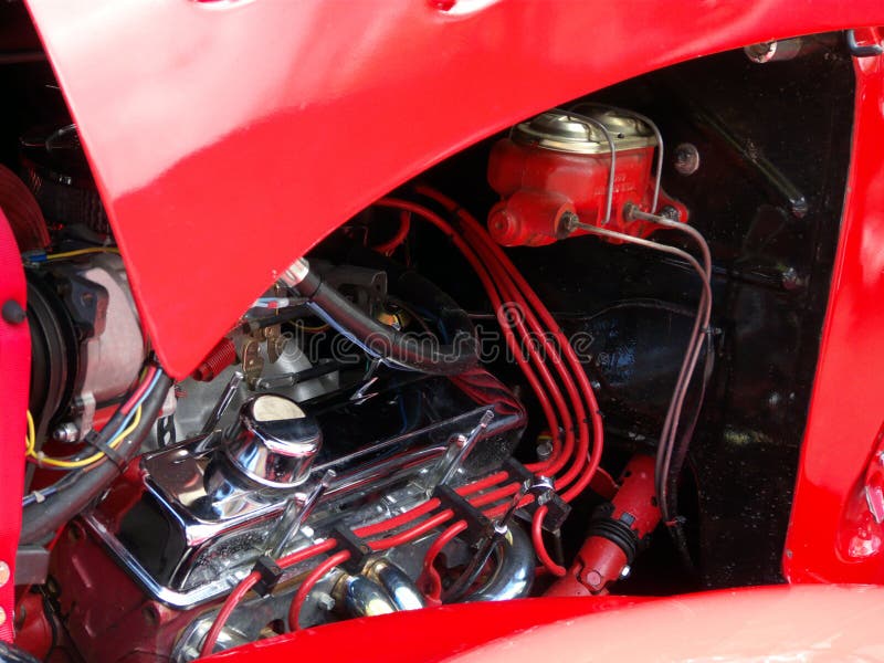 Red antique automobile with hood open and engine exposed. Red antique automobile with hood open and engine exposed