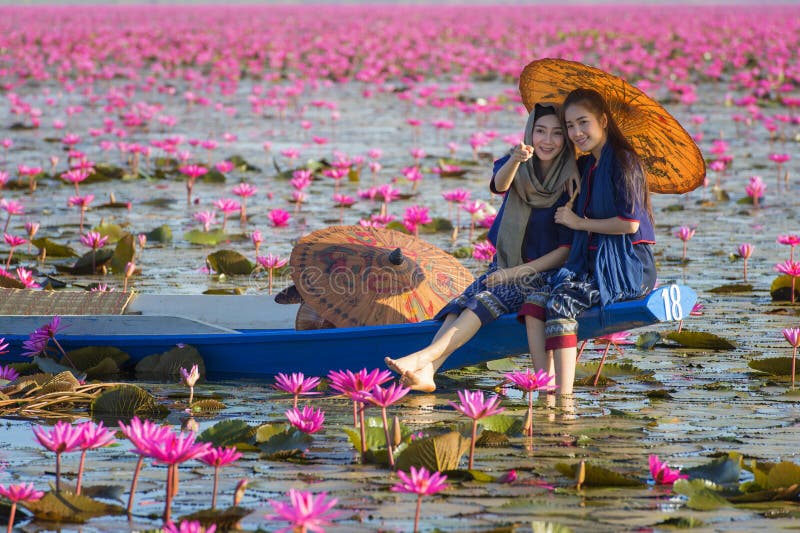 老挝妇女坐小船在花莲花湖，佩带传统泰国人的妇女 图库摄影